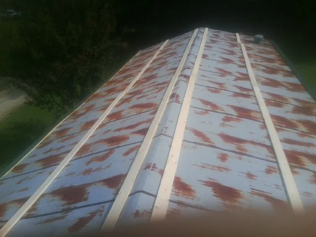 Rusted metal roof panels with new wood purlins before replacement — Storm Damage Roof Repair in Federal Way by Roofing Brothers
